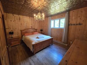 ein Schlafzimmer mit einem Bett und einem Kronleuchter in der Unterkunft Chalet COEUR de loup avec spa in Saint-Alexis-des-Monts