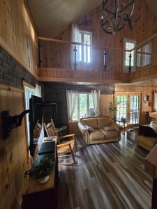 ein Wohnzimmer mit Sofa und Tisch in der Unterkunft Chalet COEUR de loup avec spa in Saint-Alexis-des-Monts