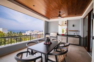 een keuken en eetkamer met een tafel en stoelen bij Huge Balcony with BBQ, Rooftop Pool and Ocean Views in Puerto Vallarta