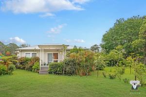 una casa en un patio con césped verde en KozyGuru | Erina | Sunny Coastal Escape + Parking, en Erina East