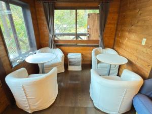 a room with two tables and chairs and windows at Santana Lodge Hakuba in Hakuba +54 photos
