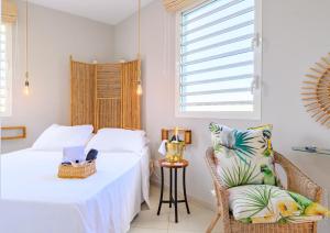 a bedroom with two beds and a chair at A L'Arche Bleue in Le Robert