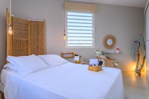 a white bed in a bedroom with a window at A L'Arche Bleue in Le Robert +90 photos