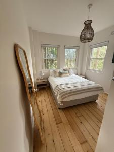 ein Schlafzimmer mit einem Bett und einem Holzboden in der Unterkunft Bondi Palms in Sydney