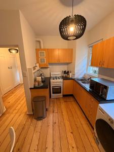 eine Küche mit Holzböden und einem weißen Herd mit Backofen in der Unterkunft Bondi Palms in Sydney