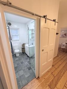 ein Badezimmer mit Toilette und Glastür in der Unterkunft Bondi Palms in Sydney + 42 Fotos