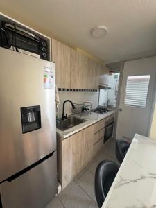 uma cozinha com uma geladeira de aço inoxidável e uma pia em Condominio Viña Oriente 2 em Viña del Mar