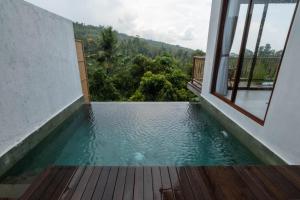 een zwembad in een huis met een raam bij Grand Abinawahill in Lovina