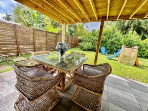 a patio with a glass table and wicker chairs at Beach and Down Town Hollywood in Hollywood