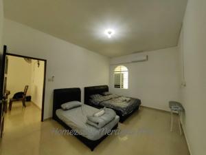 a bedroom with a bed and a couch in it at Homezstay Merdeka Miri in Miri