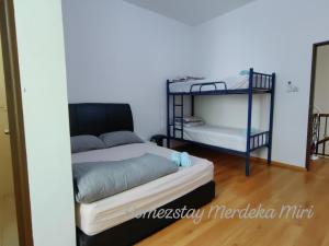 a room with two bunk beds and a mirror at Homezstay Merdeka Miri in Miri