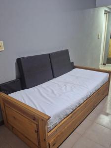 ein Holzbett mit weißer Bettwäsche in einem Zimmer in der Unterkunft Casa en Pueblo Esther in Pueblo Esther