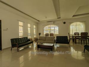 a living room with couches and a table and chairs at Homezstay Merdeka Miri in Miri +2 photos