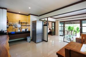 a kitchen with a stainless steel refrigerator in a room at Bang Po Hut in Ban Bang Po