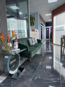 a living room with a green couch and a table at Hotel baramar moca in Moca