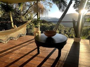 a hammock with a table and a chair on a deck at Heaven's Gate in Currumbin Valley