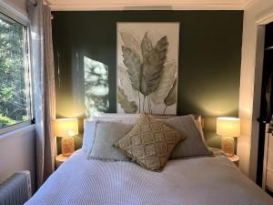 a bedroom with a bed with two lamps and a window at Heaven's Gate in Currumbin Valley