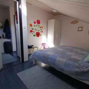 a bedroom with a bed and a wall with flowers on it at Apartment in Crikvenica 53539 in Sopaljska