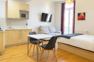 Un dormitorio con una cama y una mesa y sillas. en PUERTA DEL SOL - Vigo Centro, en Vigo