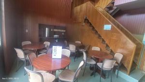 a dining room with tables and chairs and a staircase at Kiyomi's Inn in Baguio