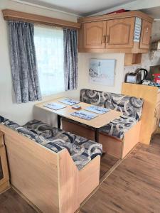 a caravan dining room with a table and couches at Ref G The Chase Caravan Park 3 bed 8 berth in Ingoldmells +14 photos