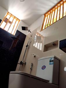 a bathroom with a refrigerator in a room at Junction 14 Villa in Dikwella North