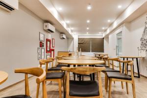 een restaurant met houten tafels en stoelen bij Super Townhouse Gandhi Hall in Indore