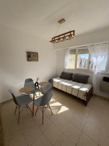 a living room with a bed and a table and chairs at Depto zona centro MDP in Mar del Plata