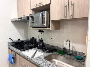a kitchen with a sink and a microwave at Team Renacer Broker Brisas del Mar and Pool in Cartagena de Indias +9 photos