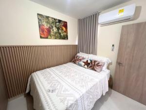 a small bedroom with a bed and a painting on the wall at Team Renacer Broker Brisas del Mar and Pool in Cartagena de Indias