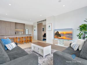 a living room with a couch and a table at CODA 410 in Coffs Harbour