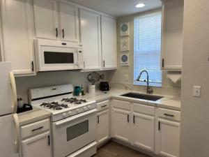 a kitchen with white cabinets and a stove top oven at Tranquil Terrace in Oceano