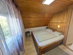 a small bed in a room with a window at Holiday home in Zamardi - Balaton 53551 in Zamárdi