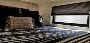 een slaapkamer met een groot bed met een raam bij Stylish Tiny House for Glamping in South Carolina in Rock Hill