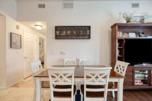 a dining room with a table and chairs and a tv at Downtown Pismo Beach modern updated single-level in Pismo Beach +18 photos