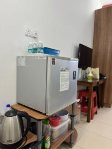 a refrigerator sitting on a shelf in a kitchen at MQA RoomStay in Sepang