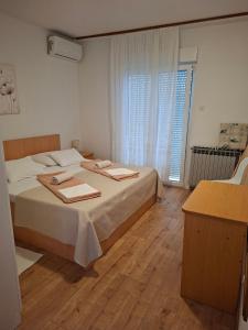 a bedroom with a bed with two towels on it at Apartments and rooms with parking space Palit, Rab - 22221 in Rab