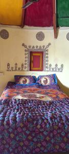 a bed with a colorful comforter in a bedroom at Rann Roshni homestay in Bherandiāla