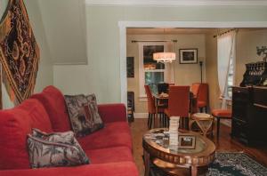 a living room with a red couch and a table at Orchard House! Recharge at Peaceful Nature Escape in Azalea