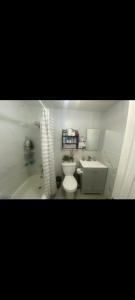 Un baño con inodoro, lavabo y bañera. en Simple room, en Paterson