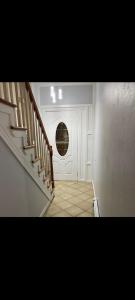 un pasillo con una puerta blanca con una ventana redonda en Simple room, en Paterson