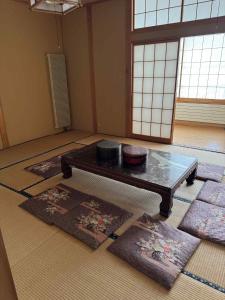 a room with mats and a table in a room with windows at Hygge KAWATABI in Osaki