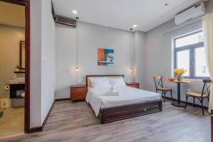 a bedroom with a bed and a table and chairs at Silana River Light Hotel in Da Nang +7 photos