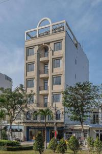 a tall white building with a balcony on it at Silana River Light Hotel in Danang
