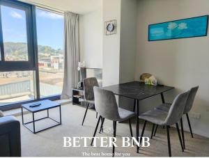 a living room with a black table and chairs at CBD Gem Cooling Summer and City View in Wellington