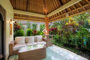 乌布Gopala Villa Ubud的客厅设有沙发,位于庭院