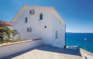 un edificio bianco con l'oceano sullo sfondo di Apartments Karlobag - Velebit Riviera 34630 a Karlobag (Carlopago)