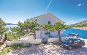 una casa con un'auto parcheggiata davanti di Apartments Karlobag - Velebit Riviera 34630 a Karlobag (Carlopago)