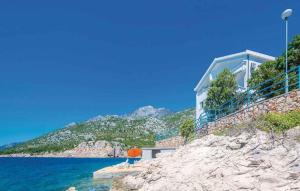 una casa su una scogliera vicino all'acqua di Apartments Karlobag - Velebit Riviera 34630 a Karlobag (Carlopago)