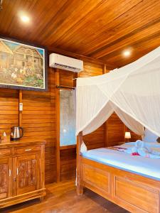 Un dormitorio con una cama en una habitación de madera. en Dewi Teduh Villa, en Sidemen